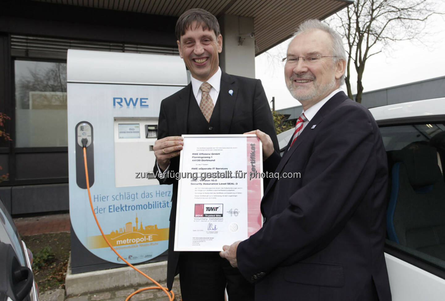 Die Geschäftsführer der RWE Effizienz, Norbert Verweyen (l.), und vom TÜV-IT, Antonius Sommer, mit dem Zertifikat für das RWE-Ladesäulensystem: TÜV-IT zertifiziert RWE-Stromladesäulen.