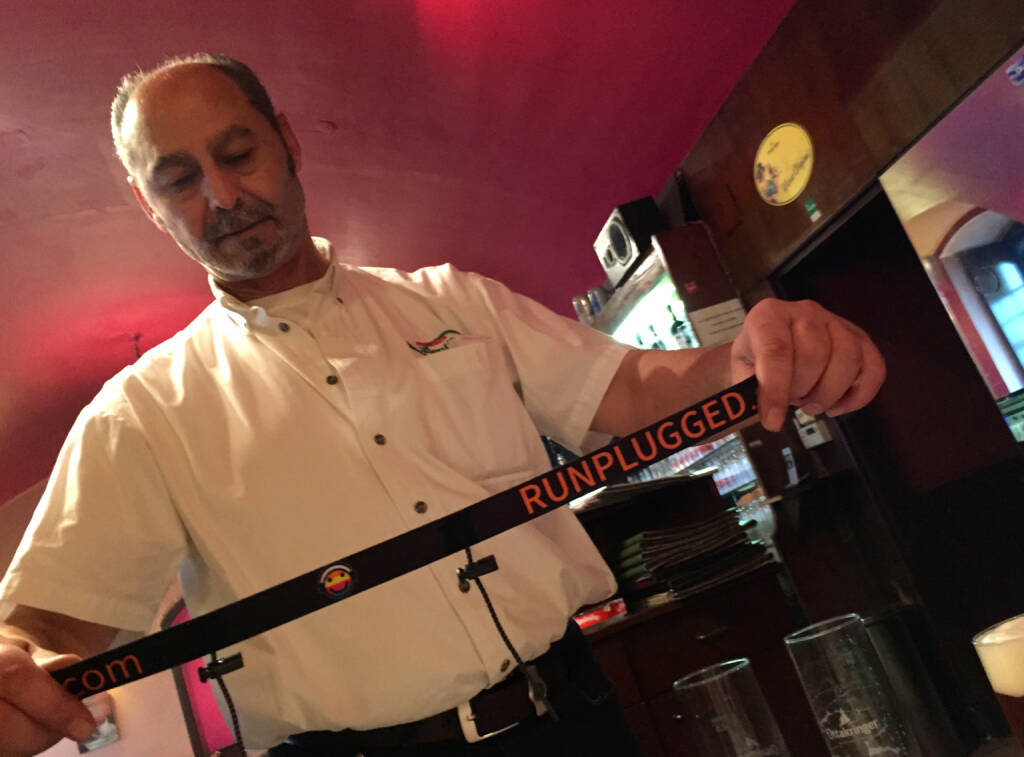 Der Besitzer der Pizzeria Valentino, der eine Runplugged Pizza gestalten wird, mit dem neuen Runplugged Startnummernband (11.12.2014) 