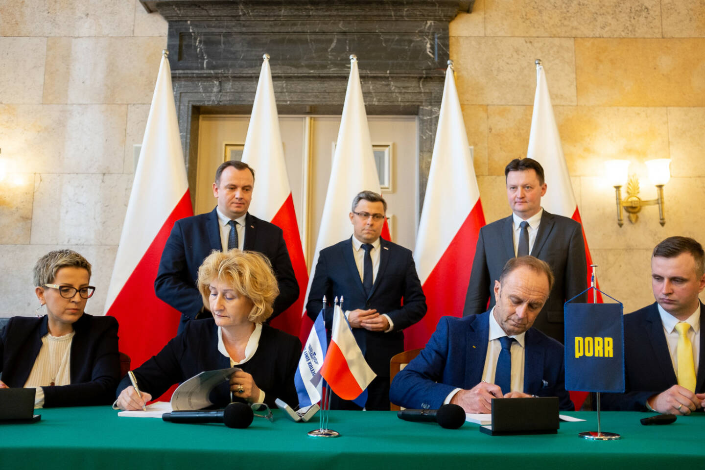 Die PORR hat von der PKP PLK S.A. den Auftrag zur Modernisierung eines Abschnitts der „Metropolitan Railway Beltway“ erhalten. PKP PLK Signing (v.l.n.r.): Edyta Swiatek (PKP PLK SA, Deputy Director of the Silesian Region for financial affairs), Bozena Kozmowska (PKP PLK SA, Deputy Director of the Silesia Region for EU projects), Jakub Chelstowski (Marshal of the Silesian Voivodeship), Jaroslaw Wieczorek (Silesian Voivode), Siegfried Weindok (Member of the Board PORR S.A.), Arnold Bresch (Member of the Board, PKP PLK SA) & Jan Chmiel (Director of the Railway Department PORR S.A., Proxy) Credit: Porr