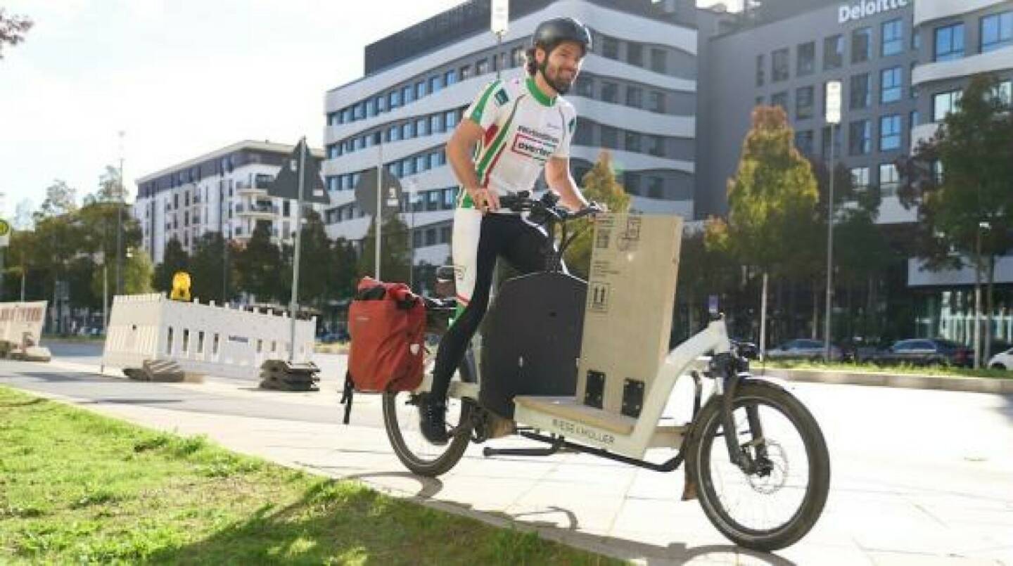 Overtec-Geschäftsführer Sebastian Hilscher legte 600 Kilometer mit dem Lastenfahrrad zurück. Seine Attika-Elemente tragen zur Umwelt- und Klimafreundlichkeit des Timber Pioneer von UBM Development  in Frankfurt am Main bei. Overtec treibt Ressourcenschonung in der Bauwirtschaft voran. Credit: Overtec