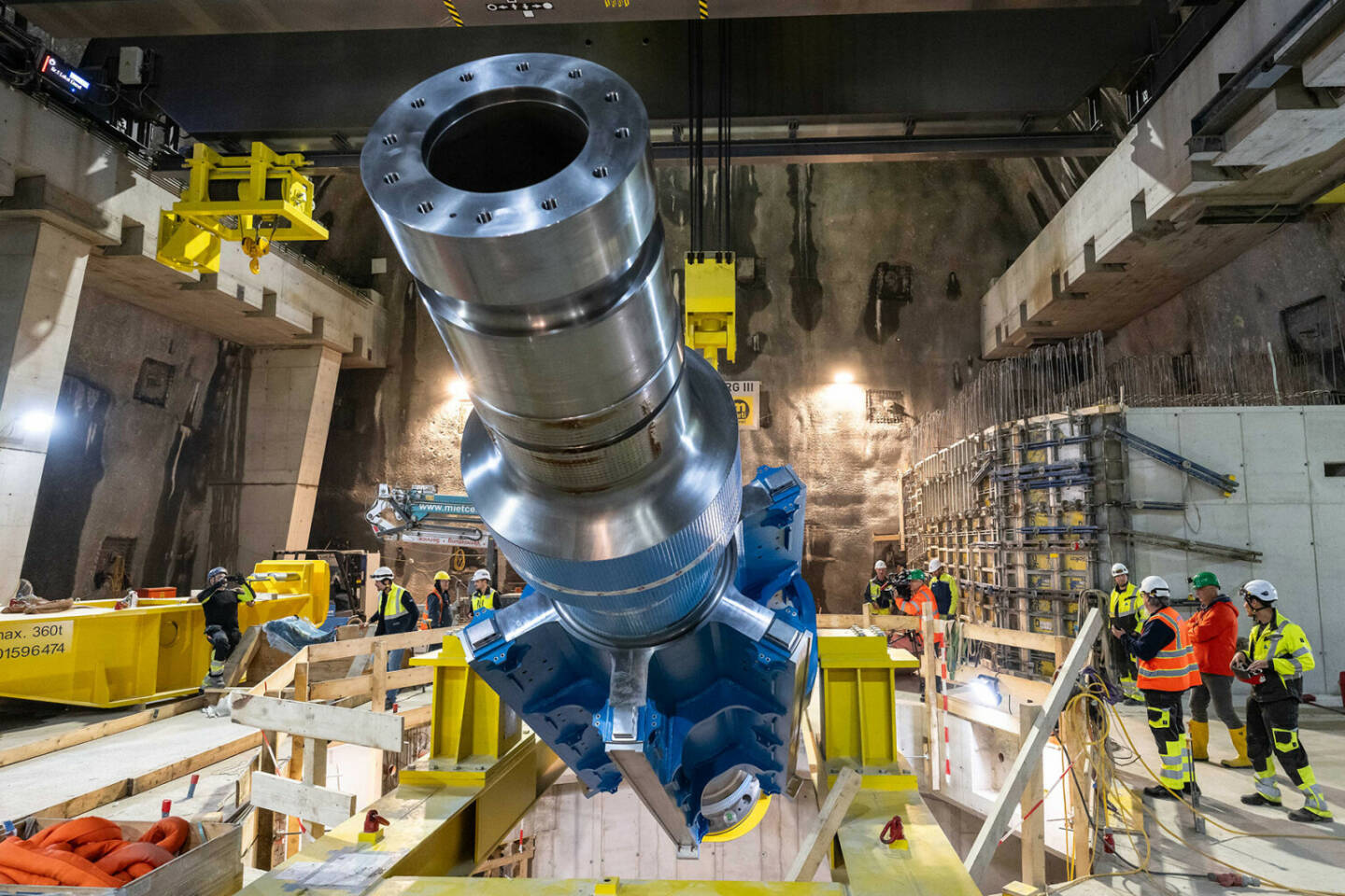 91 Tonnen schwer und 10 Meter lang ist die Welle, mit der die Kraft des Wassers auf die Turbinen von Limberg 3 übertragen werden. Der gigantische Stahlstift wurde zentimeterweise mit den Hallenkränen eingehoben. Fingerspitzengefühl, Nervenstärke und gute Abstimmung des Personals sind entscheidend. Die Rippenwelle beim Einkippen in den Turbinenschacht / VERBUND