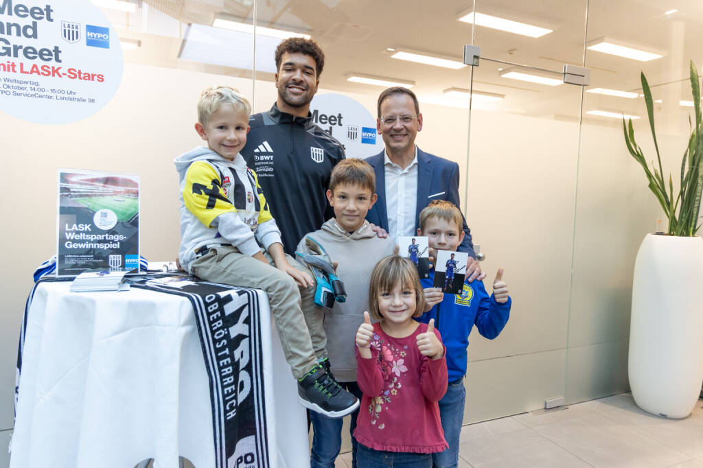 Weltspartag bei der Hypo OÖ: Klaus Kumpfmüller mit LASK-Goalie Tobias Lawal und seinen jüngsten Fans, Credits: HYPO OÖ / Cityfoto (25.10.2024) 